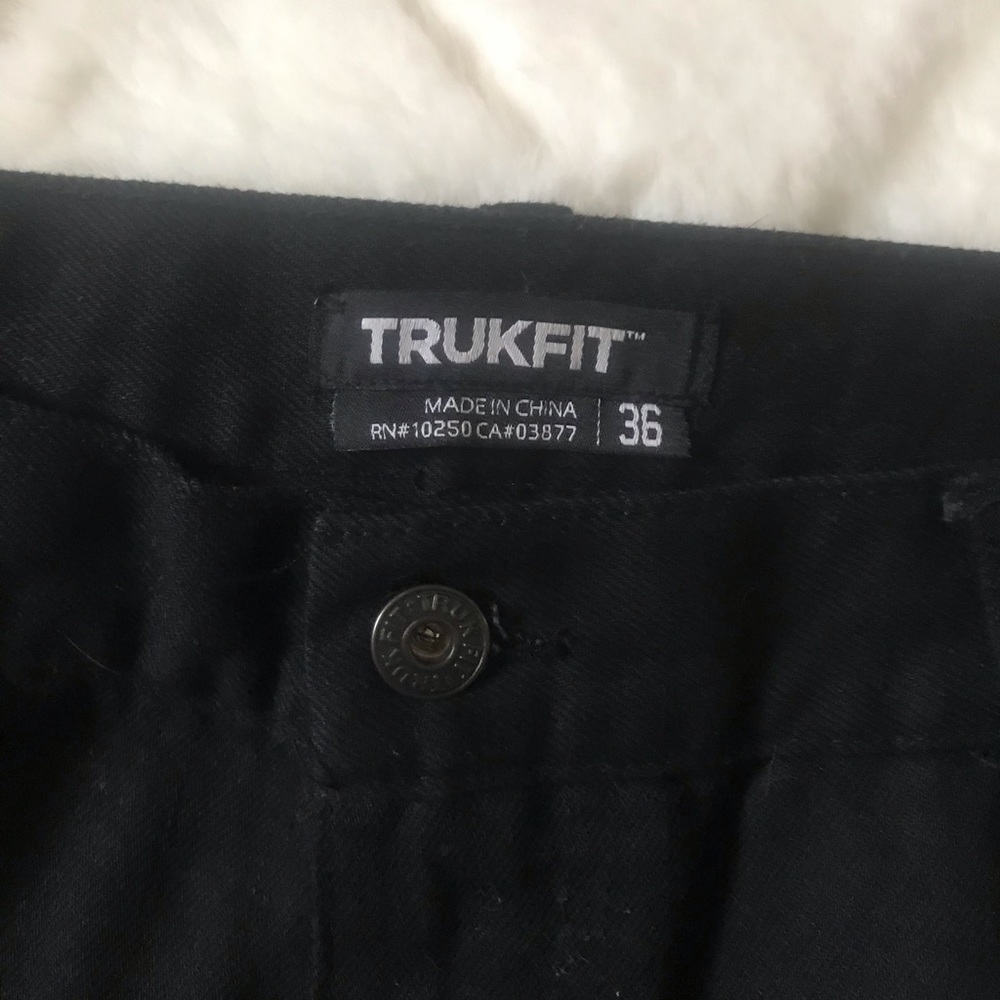 Men’s black jeans with rips in the front legs and On back pockets